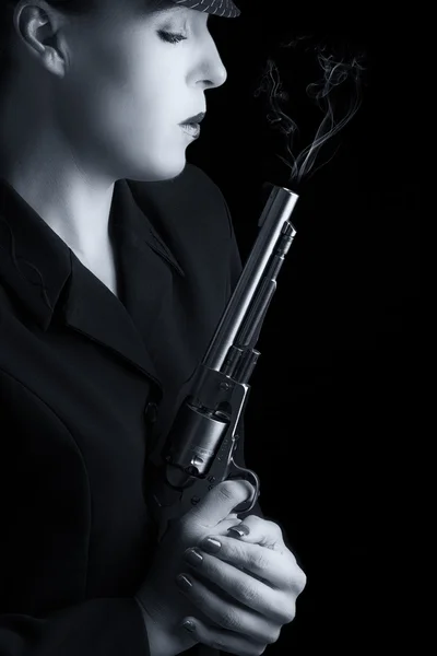 Niebezpieczne kobiety w czerni z palenia srebrny pistolet — Zdjęcie stockowe