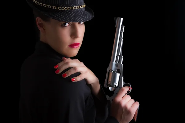 Femme dangereuse en noir avec arme de poing en argent — Photo