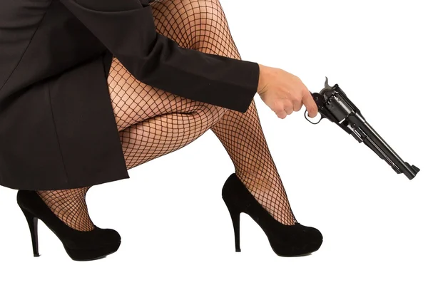 Piernas de mujer peligrosa con pistola y zapatos negros — Foto de Stock