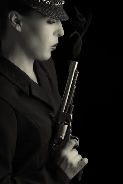 Niebezpieczne kobiety w czerni z palenia srebrny pistolet — Zdjęcie stockowe