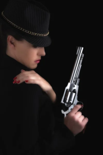 Mujer peligrosa de negro con pistola de plata — Foto de Stock