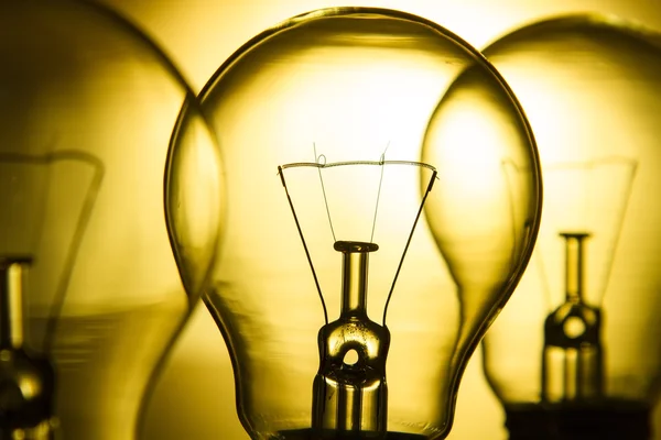 Row of light bulbs on a bright yellow background — Stock Photo, Image