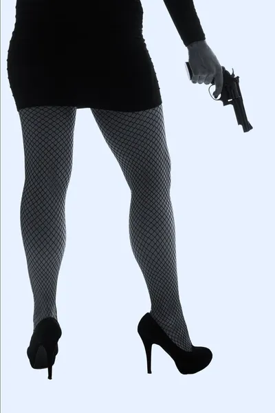 Pernas de mulher perigosa com pistola e sapatos pretos silhueta — Fotografia de Stock