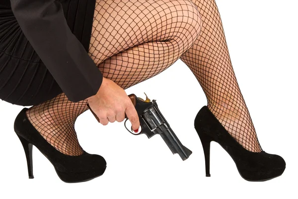 Piernas de mujer peligrosa con pistola y zapatos negros — Foto de Stock