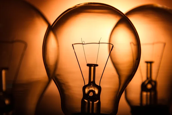 Row of light bulbs on a bright amber background — Stock Photo, Image