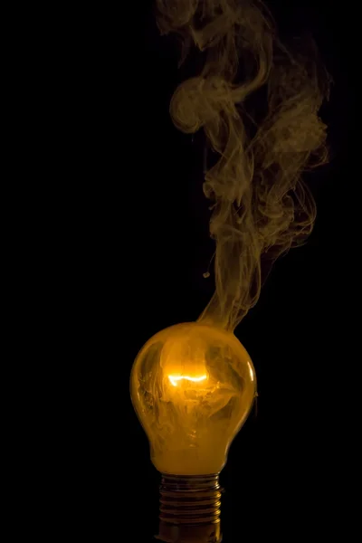 Сломанная лампочка загорелась пламенем. — стоковое фото