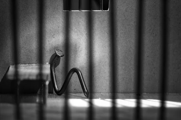 坐在酒吧化后面的铁钉的概念性监狱合影 — 图库照片