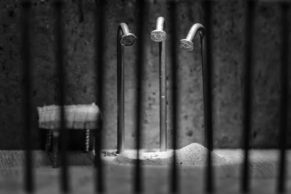 Conceptual jail photo with iron nail escaping behind out of focu — Stock Photo, Image