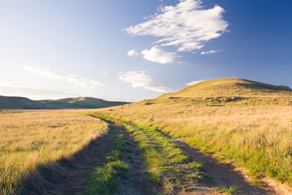 Berglandschap met weg- en dramatische wolken — Stockfoto