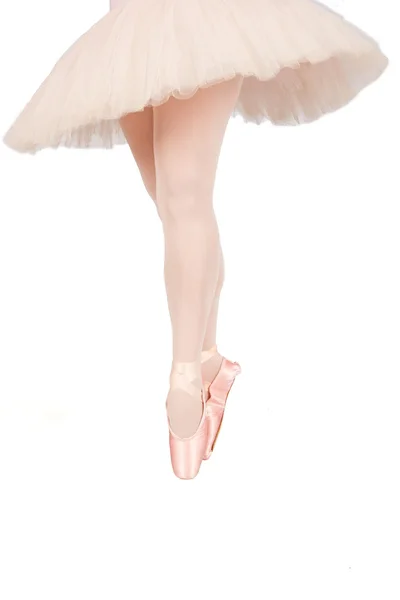 Ballet dancer standing on toes while dancing on white background — Stock Photo, Image