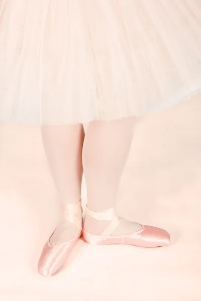 Ballet dancer standing on peach floor while dancing artistic con — Stock Photo, Image