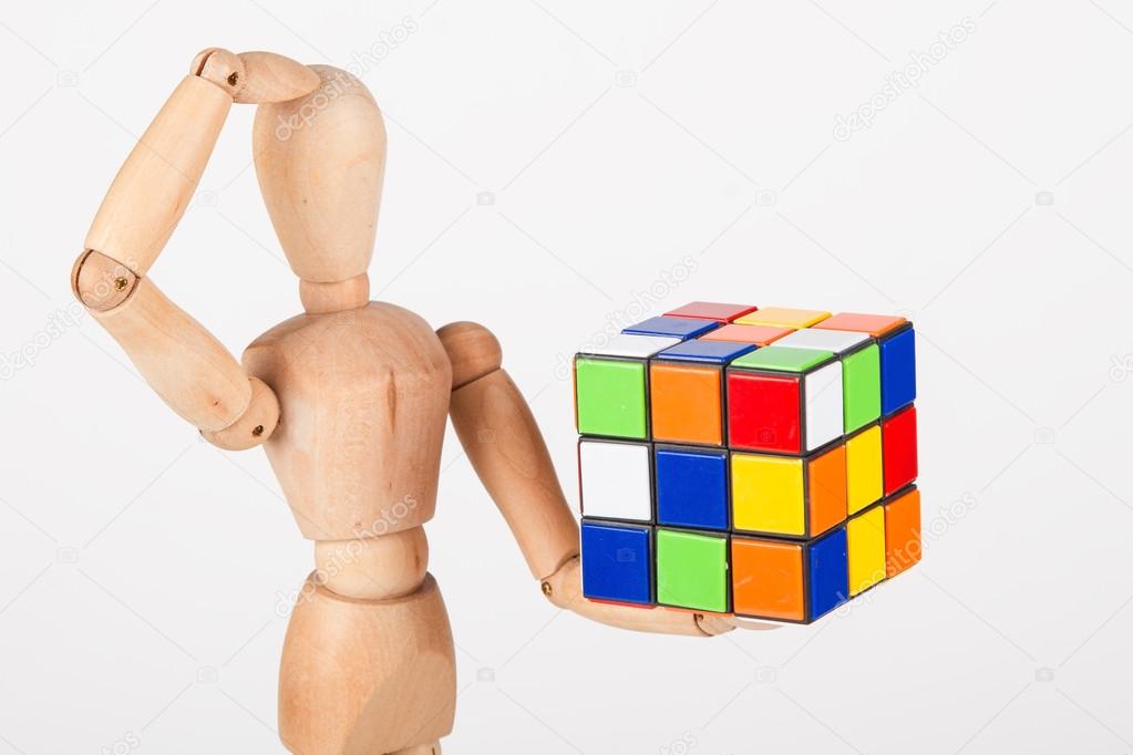 Confused wood mannequin hold cube puzzle confused before solving