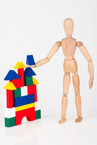 Petit mannequin en bois debout construction blocs colorés isolés sur — Photo