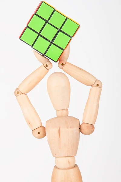 Happy wood mannequin hold cube puzzle confused after solving — Stock Photo, Image