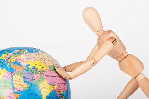 Wood mannequin push a world globe in disrespect isolated — Stock Photo, Image