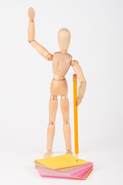 Small wood mannequin stand writing with colour pencil isolated o clipart