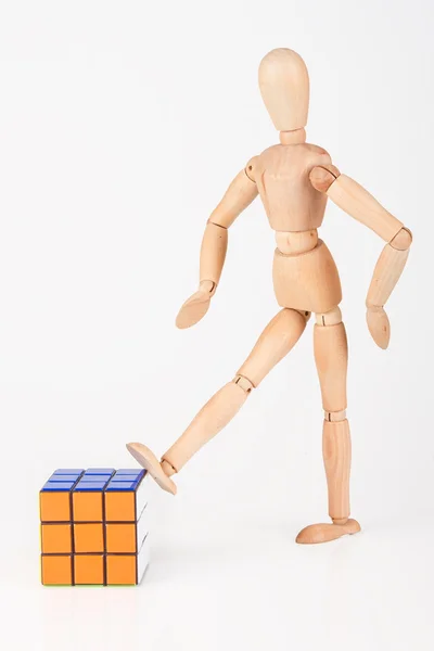 Mannequin en bois dégoûté coup de pied cube puzzle confus après la résolution — Photo