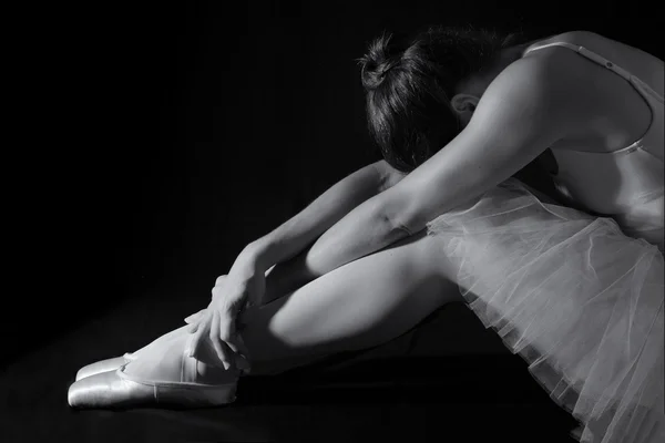 Female dancer sit on floor looking sad in pink tutu low key — Stock Photo, Image