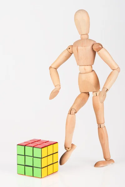 Mannequin en bois dégoûté coup de pied cube puzzle confus après la résolution — Photo