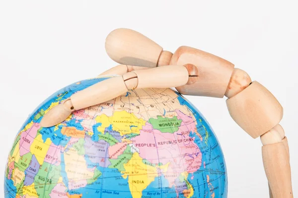 Brown wood mannequin holding concerned a globe protect — Stock Photo, Image