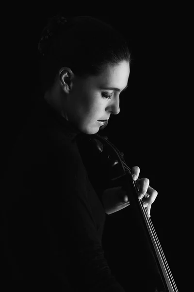 Hermosa morena tocando violonchelo con luz selectiva en d negro —  Fotos de Stock