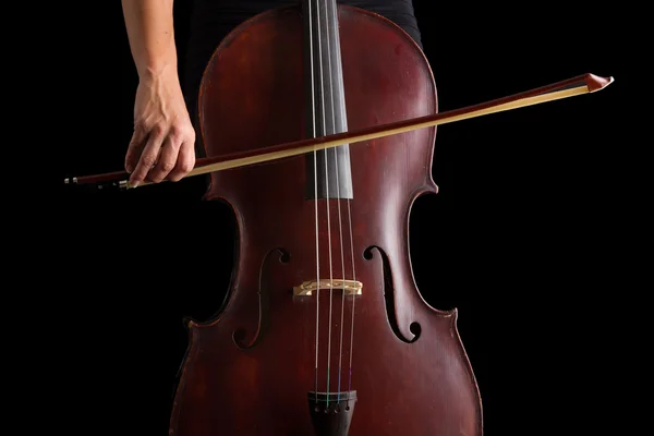 Mooie brunette spelen van cello met selectieve licht in zwarte d — Stockfoto