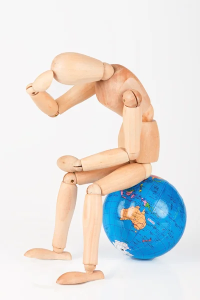 Manichino di legno seduto sulla cima di un globo mondiale per proteggere isolat — Foto Stock