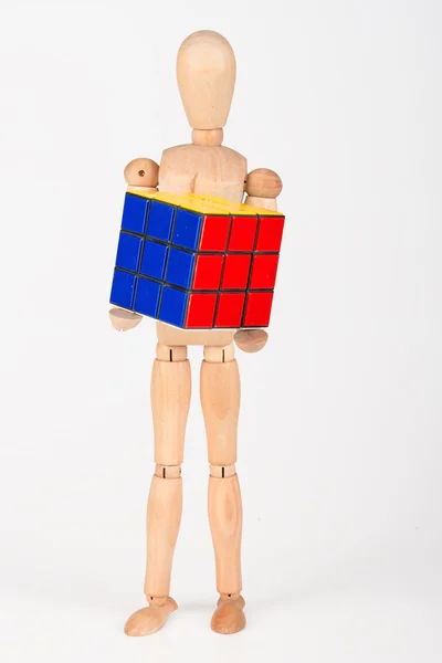 Mannequin en bois heureux tenir puzzle cube confus après la résolution — Photo