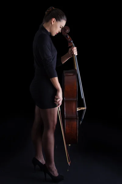 Bella bruna che tiene il violoncello con luce selettiva in nero d — Foto Stock