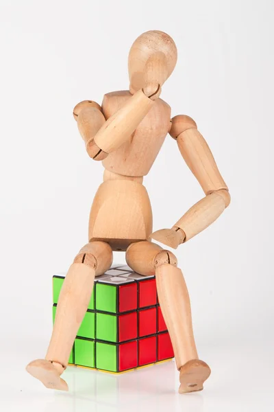 Mannequin en bois confus assis sur cube puzzle confus après solvin — Photo