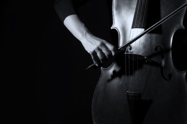 Beautiful woman holding a cello with selective light and black d clipart