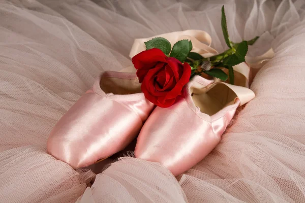 Pantofole da balletto vecchio usato sdraiato sul pavimento con rosa e tutù — Foto Stock