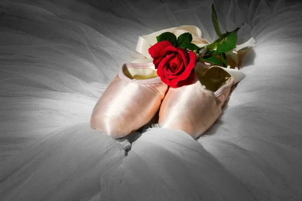 Pantofole da balletto vecchio usato sdraiato sul pavimento con rosa e tutù — Foto Stock