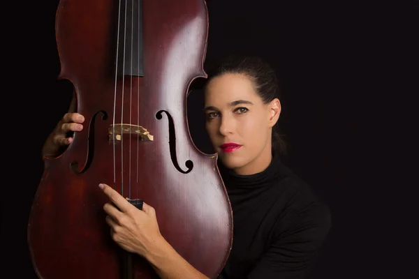 Hermosa morena sosteniendo violonchelo con luz selectiva en d negro — Foto de Stock