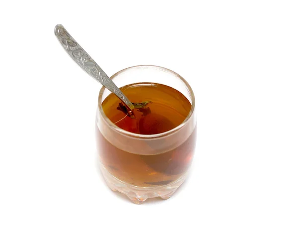 Xícara de chá com uma colher em um fundo branco — Fotografia de Stock