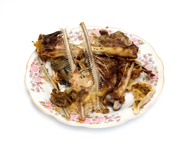 Résidus de nourriture, os de poisson et de poulet sur une assiette — Photo