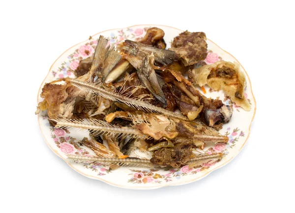Остатки пищи, кости рыбы и курицы на тарелке — стоковое фото