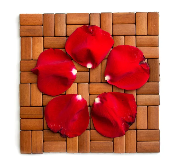 木制背景上红玫瑰的花瓣 — 图库照片