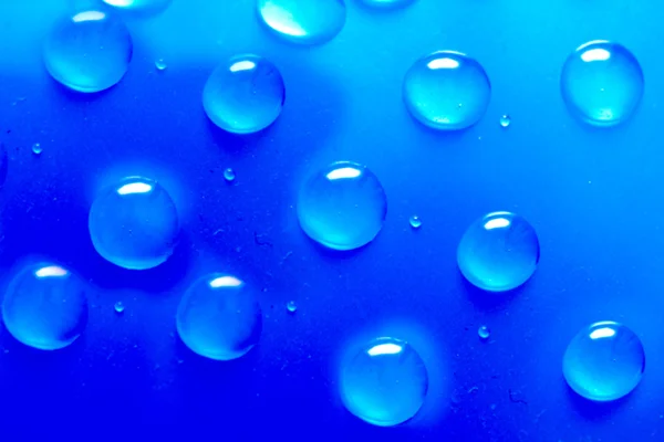 Gotas de água sobre um fundo azul. macro — Fotografia de Stock