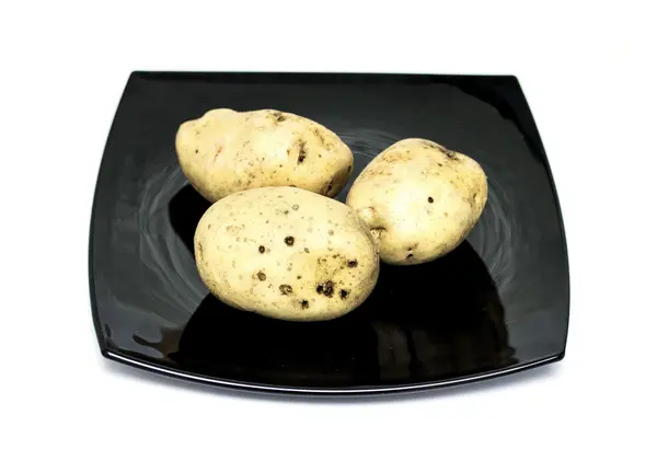 Raw potatoes on the plate — Stock Photo, Image