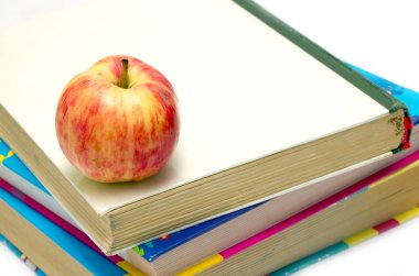 bir kitap yığını üzerinde elma