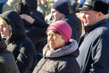 Petropavlovsk, Kazakistan - 06 Mart 2022: Kış güneşli bir günde kalabalığın içindeki insanların yüzleri.