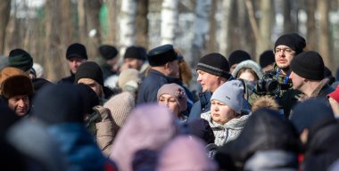 Petropavlovsk, Kazakistan - 06 Mart 2022: Kış güneşli bir günde kalabalığın içindeki insanların yüzleri.