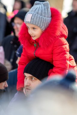 Petropavlovsk, Kazakistan - 06 Mart 2022: Kalabalıktaki çocuklara yakın çekim. Başla. Çocuklar gösteriyi izlemek için ailelerinin boynuna otururlar.