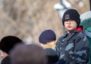 Petropavlovsk, Kazakistan - 06 Mart 2022: Kış güneşli bir günde kalabalığın içindeki insanların yüzleri.