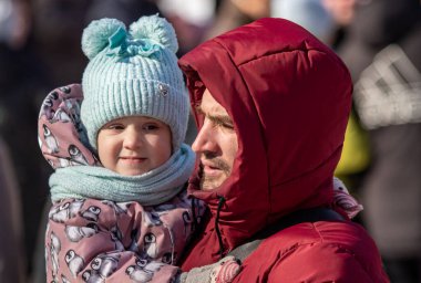 Petropavlovsk, Kazakistan - 06 Mart 2022: Kalabalıktaki çocuklara yakın çekim. Başla. Çocuklar gösteriyi izlemek için ailelerinin boynuna otururlar.