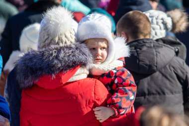 Petropavlovsk, Kazakistan - 06 Mart 2022: Kalabalıktaki çocuklara yakın çekim. Başla. Çocuklar gösteriyi izlemek için ailelerinin boynuna otururlar.