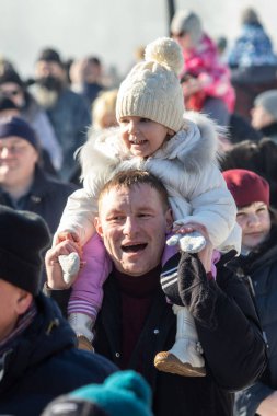 Petropavlovsk, Kazakistan - 06 Mart 2022: Kalabalıktaki çocuklara yakın çekim. Başla. Çocuklar gösteriyi izlemek için ailelerinin boynuna otururlar.