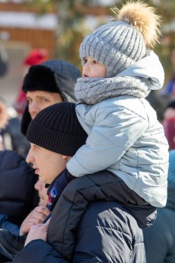 Petropavlovsk, Kazakistan - 06 Mart 2022: Kalabalıktaki çocuklara yakın çekim. Başla. Çocuklar gösteriyi izlemek için ailelerinin boynuna otururlar.