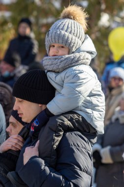 Petropavlovsk, Kazakistan - 06 Mart 2022: Kalabalıktaki çocuklara yakın çekim. Başla. Çocuklar gösteriyi izlemek için ailelerinin boynuna otururlar.
